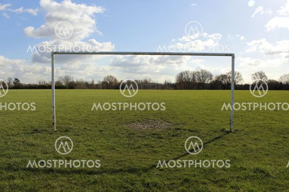 Goal Posts On A Field In The Sun With Blue Sky And Clouds