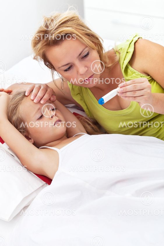 Woman checking her daughter's temperature
