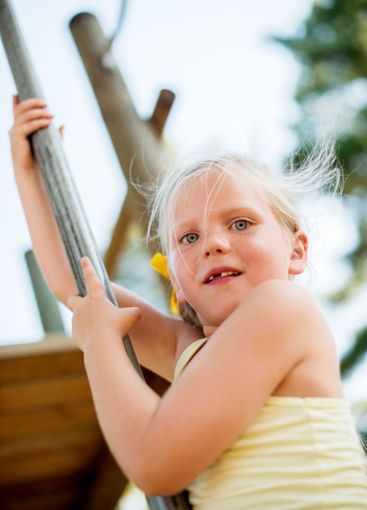 Child, portrait and pole on playground for slide, fun...