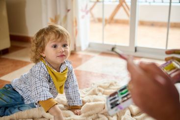 Young Child Engaged in Playtime With Parent Indoors on a...