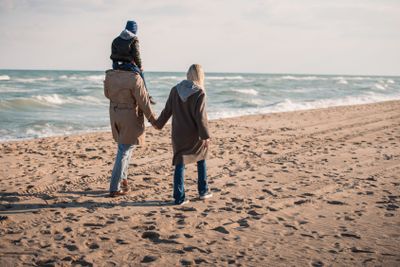 family walking on seashore in autumn