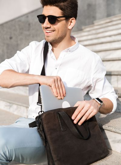 Photo of handsome man 30s wearing sunglasses, putting...