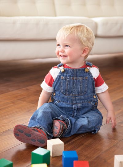 Young Boy Playing With Coloured Blocks At Home