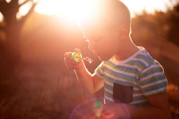 Bubbles, sun and kid in park with fun, adventure play...