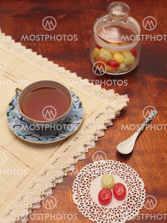 Tea with coloured sugar candies in a glass can