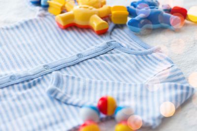 close up of baby bodysuit for newborn and rattle