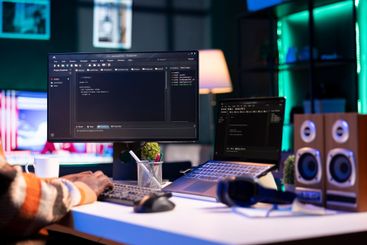 Black programmer remotely working in home office writing...