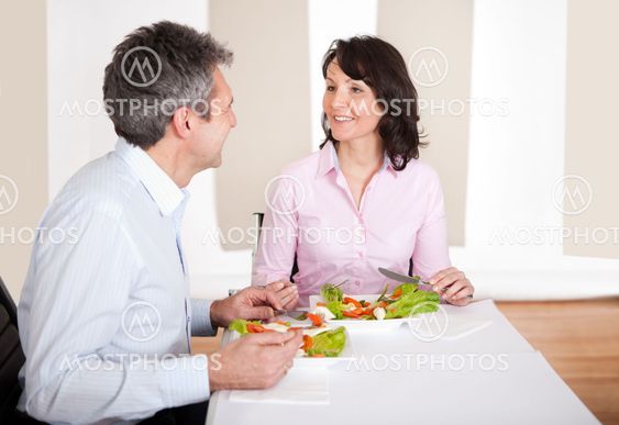 Mature couple having lunch at home