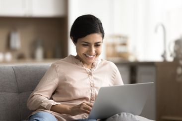 Portrait smiling young girl using notebook sitting on...