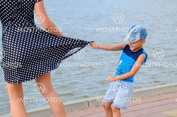 The little boy looks under his skirt. Children's pranks....