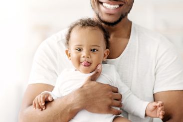 Closeup Shot Of Cute Funny Black Baby Boy Relaxing In...