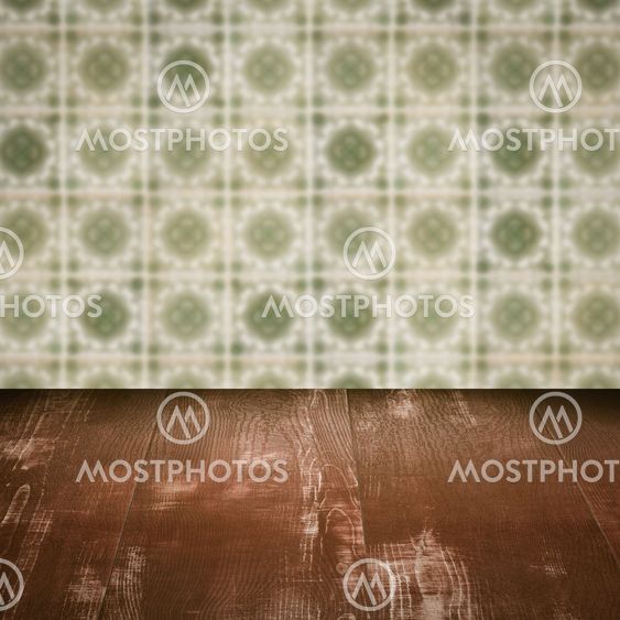Wood table top and blur vintage ceramic tile pattern wall