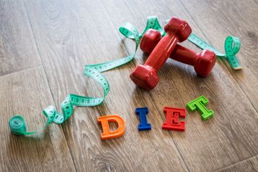 Fitness concept with dumbbells and measuring tape