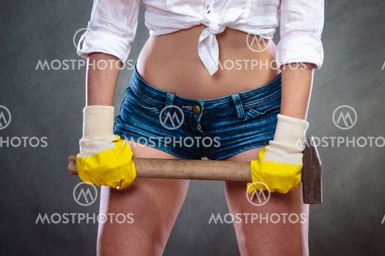 Closeup of sexy woman holding hammer. Feminism.