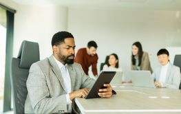 Engaged professional focuses on tablet amidst...