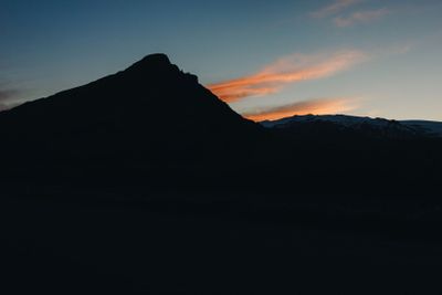 scenic view of mountain in dusk and dramatic sky during...