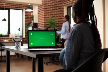 Woman using laptop with greenscreen