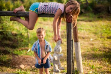 A brother and sister, playing together in a village