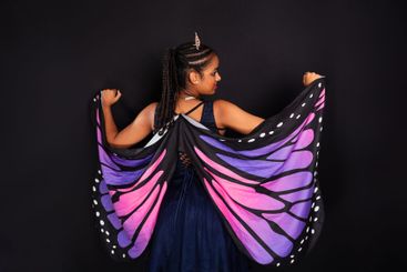 Brunette teenager wearing butterfly wings with her back...