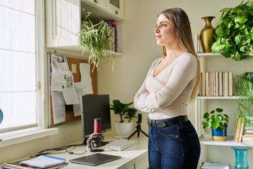 Portrait of young confident smiling woman in home interior