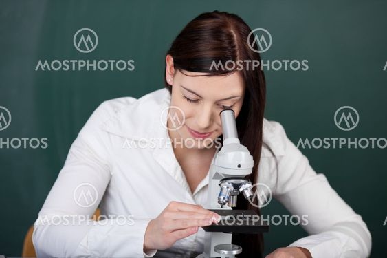 Young female student using a microscope