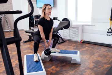 Sportswoman in black sportswear standing on step...