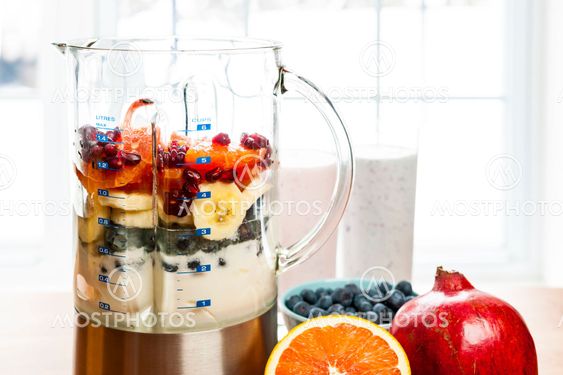 Making smoothies in blender with fruit and yogurt