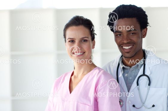 A doctor and a nurse smiling at the camera