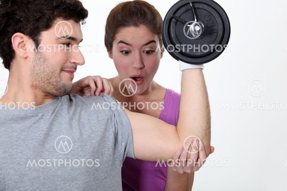 Amazed woman looking at her boyfriend's new muscles