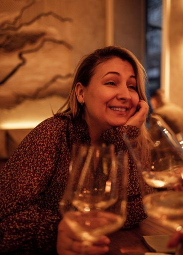 A young woman raising a glass of champagne at a festive...