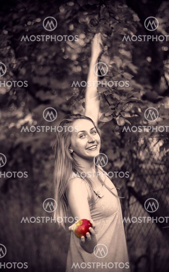 Smiling blond young woman in a garden