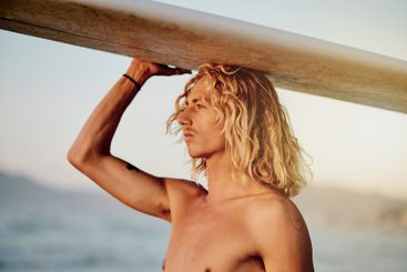 Sports, surfer and man at a beach with surfboard for...