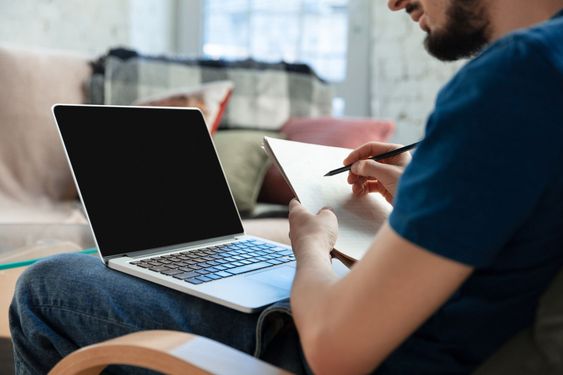Young focused man studying at home during online courses...
