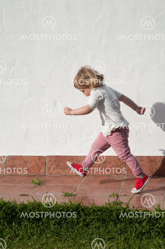 walking little child in garden over white wall