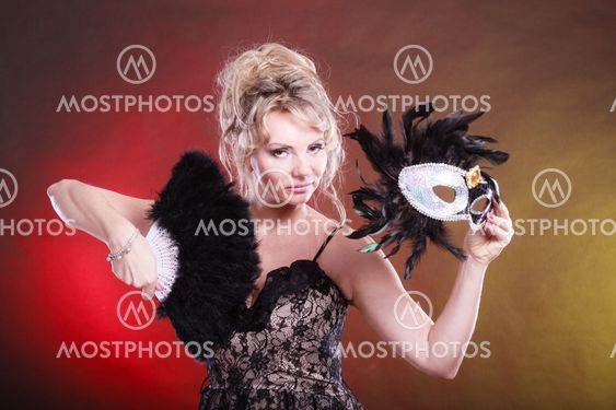 Woman holding carnival mask feather fan in hand