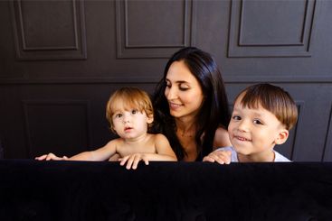 Young mother and her two little boys are playing at...