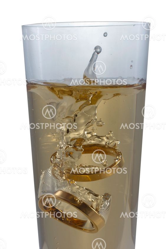 Champagne glass with engagement rings, isolated on white