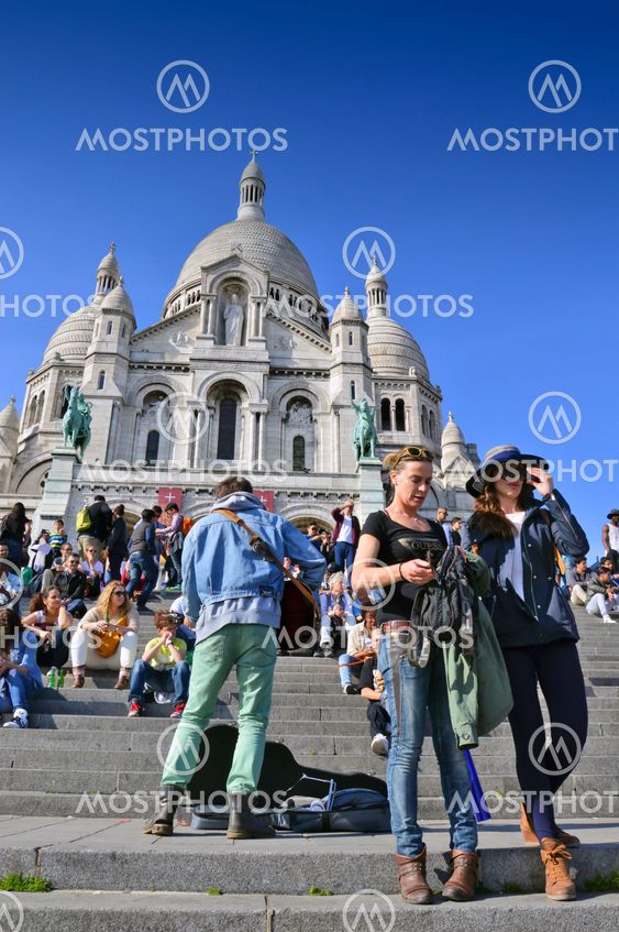 Tourists visiting the Basilica of the Sacred Heart of Paris, a Roman Catholic church and minor basilica, located at the summit of the butte Montmartre, the highest point of Paris
