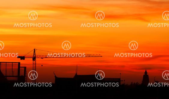Industrial construction cranes and building at sunrise