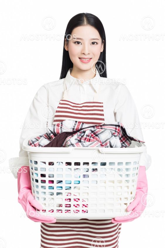 woman doing a housework holding basket of laundry