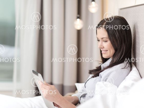 happy businesswoman with tablet pc in hotel room