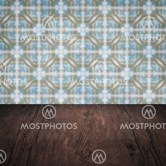 Wood table top and blur vintage ceramic tile pattern wall