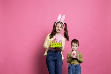 Sweet children holding festive easter decorations on camera