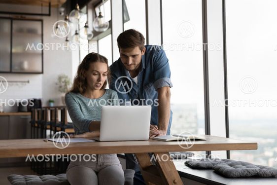 Diverse employees work together on laptop in office