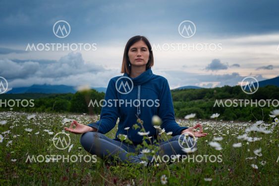 A young woman doing yoga in the field.