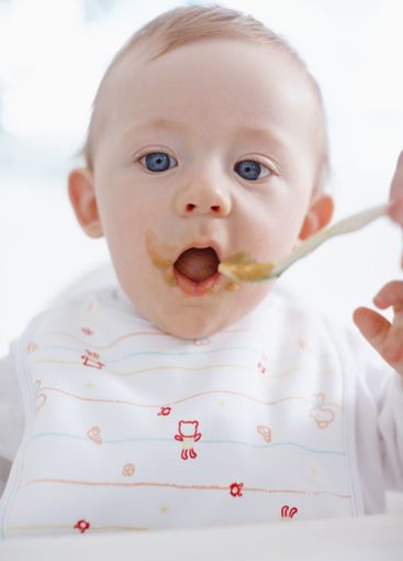 Baby, parent hands and feeding food in home, hungry and...