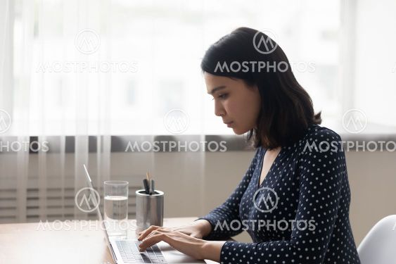 Close up confident Asian woman working on laptop, typing