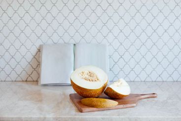 Close up of juicy sliced melon on a wooden chopping...