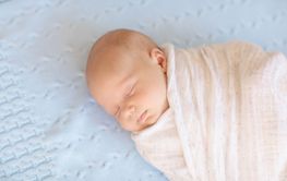 Little baby on white bed