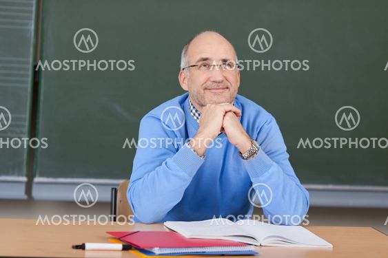 Thoughtful Professor With Hands On Chin Looking Up At Desk